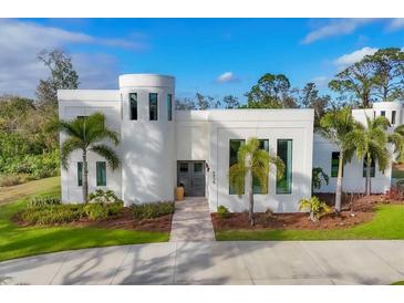 Modern white stucco home with palm trees and circular driveway at 6939 Bee Ridge Rd, Sarasota, FL 34241