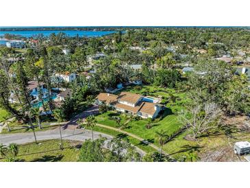 Expansive aerial view of a property with lush landscaping, pool, and well-maintained lawn near the water at 7820 Seville Cir, Bradenton, FL 34209