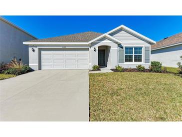 Single-story house with white garage door and gray siding at 12226 Kingsley Trl, Parrish, FL 34219