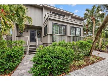 Two-story home with gray siding, multiple balconies, and lush landscaping at 1444 Landings Cir # 72, Sarasota, FL 34231