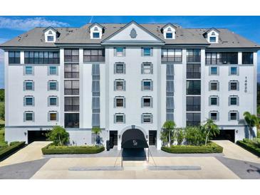 Beautiful condo building with manicured landscaping, covered entrance, and a neutral color scheme at 14820 Rue De Bayonne # 308, Clearwater, FL 33762
