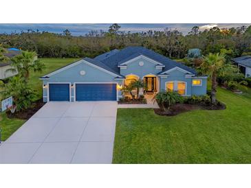 Charming single-Gathering home features a three-car garage, lush green lawn, and mature palm trees at 16307 29Th E Ct, Parrish, FL 34219