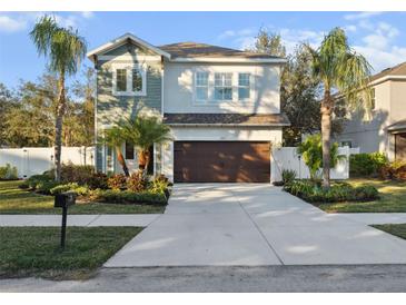 Two-story house with a brown garage door and nicely landscaped yard at 2511 Prospect St, Sarasota, FL 34239