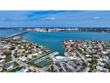 Stunning aerial view of a waterfront property with boat dock, tennis courts, and views of Sarasota Bay at 279 Robin Dr, Sarasota, FL 34236