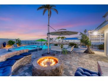 Expansive patio with firepit, pool, and seating area at sunset at 3611 99Th W St, Bradenton, FL 34210