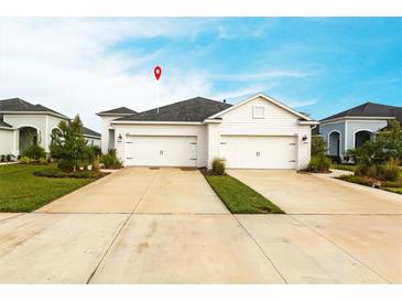 A well-maintained home featuring a two-car garage, well-manicured landscaping, and a long driveway at 4739 Willow Bend Ave, Parrish, FL 34219