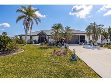 Landscaped front yard with mature palm trees and well-manicured lawn at 949 Chevy Chase St, Port Charlotte, FL 33948