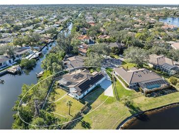 Aerial view showing home's backyard, pool, and location on a canal at 1060 Water Oak Ne Ct, St Petersburg, FL 33703