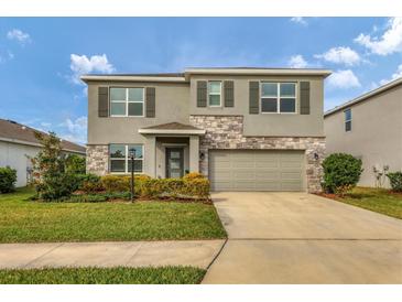 Two-story house with gray siding, stone accents, and a two-car garage at 17209 Barnwood Pl, Bradenton, FL 34211