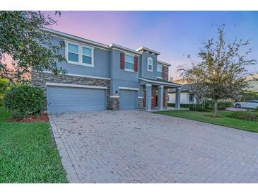 Charming two-story home with a three-car garage, brick driveway, stone accents, and well-maintained landscaping at 5001 65Th E Ter, Ellenton, FL 34222