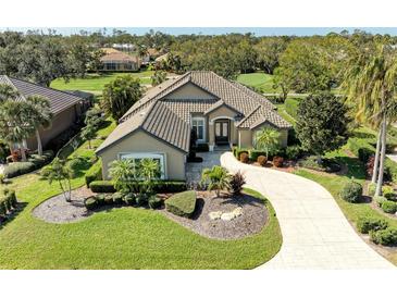 Aerial view of a single Gathering home with well-manicured lawn, mature trees, and golf course views at 5304 96Th E St, Bradenton, FL 34211