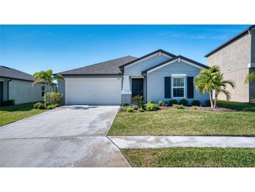 One-story home with gray siding, a two-car garage, and a well-manicured lawn at 8547 40Th E Cir, Palmetto, FL 34221