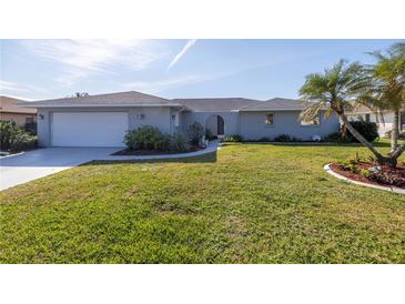 Gray house with white garage door and well-maintained lawn at 1006 Pine Forest Ct, Venice, FL 34293