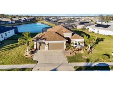 Single-Gathering home with a three-car garage, situated on a pond in a quiet community at 12822 Rainwashed Loop, Parrish, FL 34219