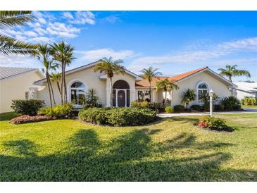 Single-story home with tile roof, lush landscaping, and a large front yard at 1441 Gleneagles Dr, Venice, FL 34292