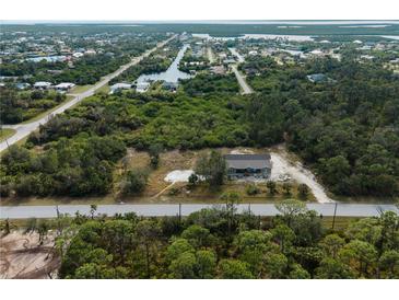 An aerial view shows this house with an expansive lot surrounded by lush greenery and proximity to community waterways at 17555 Lake Worth Blvd, Port Charlotte, FL 33948