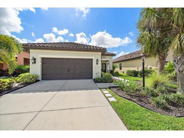 Single-story home with a two-car garage and landscaped front yard at 220 Alfero Way, Nokomis, FL 34275