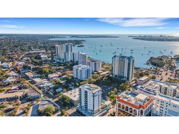 An aerial view of a coastal city featuring high-rise buildings, lush greenery, and stunning ocean views at 300 S Pineapple Ave # 802, Sarasota, FL 34236