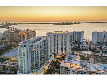 Stunning aerial view of luxury high-rise condos overlooking the ocean at sunset, showcasing prime waterfront real estate at 301 Quay Commons # 1411, Sarasota, FL 34236