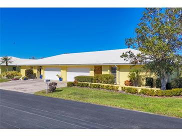 Bright yellow house with white roof, two-car garage, and well-manicured landscaping at 3749 Amesbury Ln # 5608, Sarasota, FL 34232