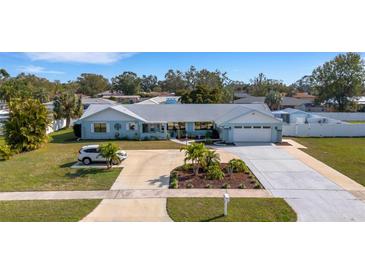 Attractive light blue single-story home with a large driveway and landscaping at 512 Whitfield Ave, Sarasota, FL 34243