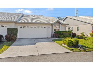 Exterior of charming villa with white vinyl siding, and a well-manicured lawn at 5388 Pamela Wood Way # 8, Sarasota, FL 34233