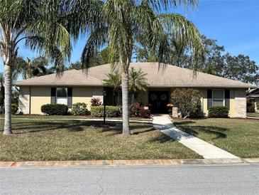 Single-story home with palm trees and landscaped yard at 5507 Country Lakes Trl, Sarasota, FL 34243