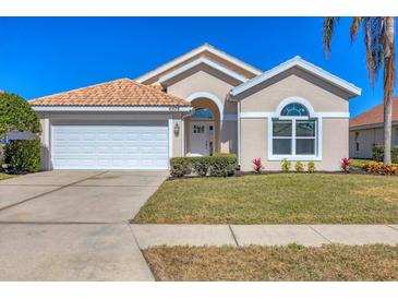 One-story house with tan walls, tile roof, and a two-car garage at 6978 Superior Street Cir, Sarasota, FL 34243