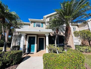 Two-story condo building with teal doors and lush landscaping at 7615 River Oak Run # 103, Lakewood Ranch, FL 34202