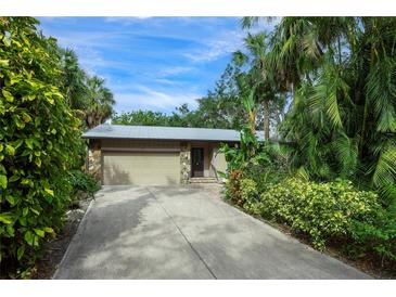 Tan house with attached garage, stone accents, and lush landscaping at 1155 Hampton Rd, Sarasota, FL 34236