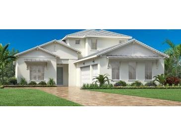 Two-story house with white exterior, two-car garage, and manicured lawn at 17903 Palmiste Dr, Bradenton, FL 34202