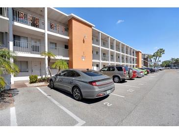 Three-story condo building with assigned parking and tropical landscaping at 2211 Sunset Dr # E3, Bradenton, FL 34207