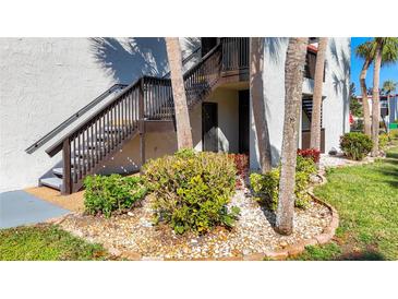 Charming condo building with well-maintained landscaping and appealing wooden staircase to upper levels at 3273 Beneva Rd # 101, Sarasota, FL 34232