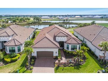 Aerial view of a single-story home with a tile roof, well-maintained lawn, and mature landscaping at 3860 Santa Caterina Blvd, Bradenton, FL 34211