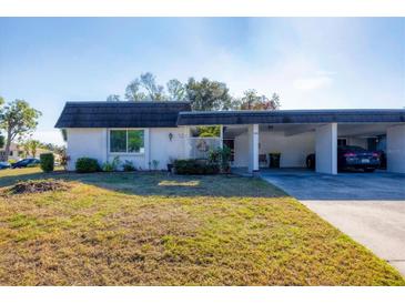 Front view of a single story home with carport and landscaped lawn at 3990 Overlook Bnd # 19, Sarasota, FL 34232