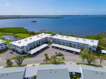 Aerial view of a three-story condo building with covered parking and beautiful bay views at 4722 Independence Dr, Bradenton, FL 34210