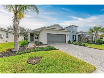 Newly built home with gray garage door, landscaping, and paved driveway at 5866 Bungalow Grove Ct, Palmetto, FL 34221