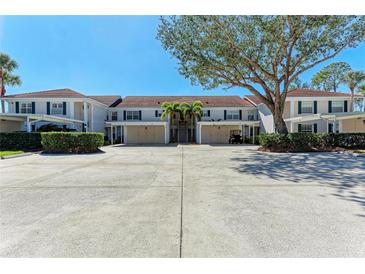 Two-story condo building with covered parking and lush landscaping at 803 Montrose Dr # 201, Venice, FL 34293