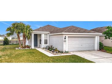 One-story home with landscaped lawn, attached garage, and palm trees at 9918 50Th Street E Cir, Parrish, FL 34219