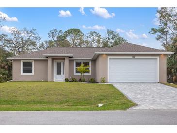 Charming single-story home with a well-manicured lawn, neutral tones, and a two-car garage at 336 Milford St, Port Charlotte, FL 33953