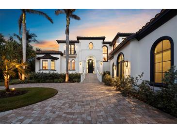 Elegant two-story estate with a manicured lawn, grand entrance, and beautiful architectural features at 500 Harbor Point Rd, Longboat Key, FL 34228