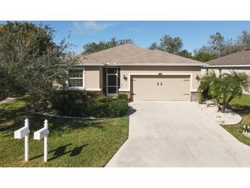 Charming home with a well-maintained lawn, landscaped bushes, and a two-car garage at 5718 Broad River Run, Ellenton, FL 34222