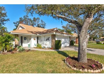 Charming single-story home featuring a well-maintained lawn, white exterior, and a beautiful tile roof at 5718 Garden Lakes Palm, Bradenton, FL 34203