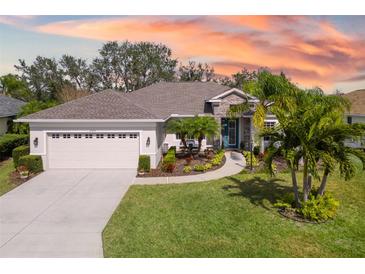 Charming one-story home with a well-manicured lawn, palm trees, and beautiful landscaping at 6373 Royal Tern Cir, Bradenton, FL 34202