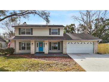 Two-story house with a stone facade, two-car garage, and landscaped lawn at 7805 Capwood Ave, Temple Terrace, FL 33637