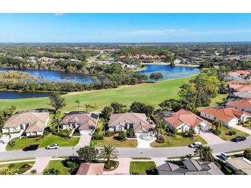 Beautiful aerial view of homes near golf course and lake in a well landscaped community at 8727 Grey Oaks Ave, Sarasota, FL 34238