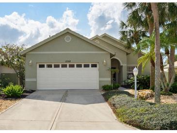 Charming single-story home featuring a two-car garage and manicured landscaping at 1358 Berkshire Ct, Venice, FL 34292