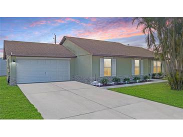 Charming single-story home with a well-manicured lawn, stone accents, and a two-car garage at 1406 14Th Street W Ct, Palmetto, FL 34221
