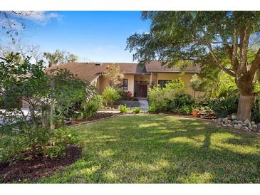 Charming single-story home with lush front yard landscaping, mature trees, and inviting entryway at 1529 Oak Way, Sarasota, FL 34232