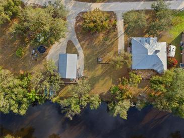 Aerial view of a charming home with a matching detached garage situated on a riverfront property at 27350 San Carlos Dr, Punta Gorda, FL 33983